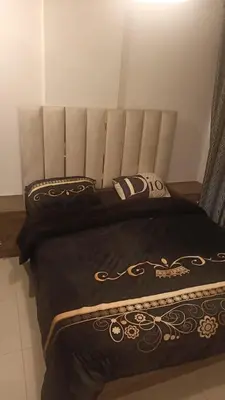 a bed with a black comforter and a pillow at lNTERCoNTlNENTALAL in Amman