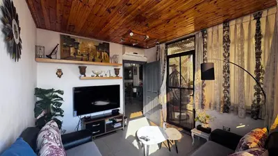 a living room with a couch and a tv at Cozy and well-located 2 bedroom flat near a mall in Amman