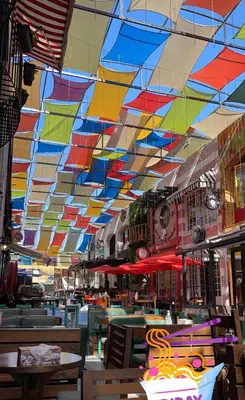 a restaurant with a colorful ceiling and tables and chairs at Cozy and well-located 2 bedroom flat near a mall in Amman