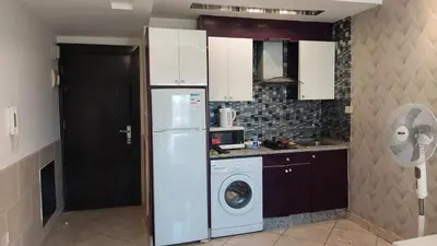 a kitchen with a refrigerator and a washing machine at Nice cozy place in Amman