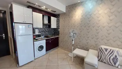 a kitchen with a refrigerator and a washing machine at Nice cozy place in Amman