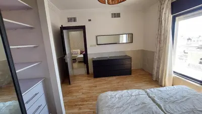 a bedroom with a bed and a dresser and a mirror at Nice cozy place in Amman