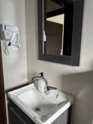a bathroom sink with a mirror and a hair dryer at The view in Māḩiş