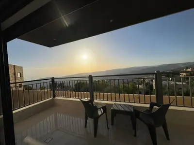 a balcony with two chairs and a table with a view at The view in Māḩiş