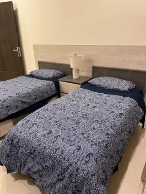 a bedroom with two beds with blue comforters at The view in Māḩiş