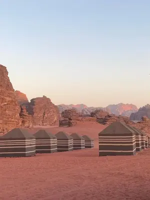 a row of domes in the desert with mountains at Crescent Camp & Tours in Wadi Rum
