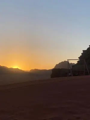 a sunset on a beach with a soccer goal at Crescent Camp & Tours in Wadi Rum