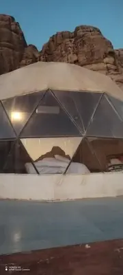 a glass window of a bed in a desert at Shadow of Rum camp in Wadi Rum
