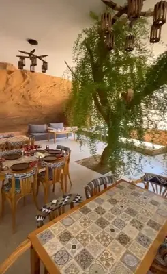 a room with a table and chairs and a tree at Siq Rum Luxury Camp in Wadi Rum
