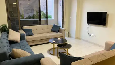 a living room with couches and a flat screen tv at Flow - Al Raha Village in Aqaba