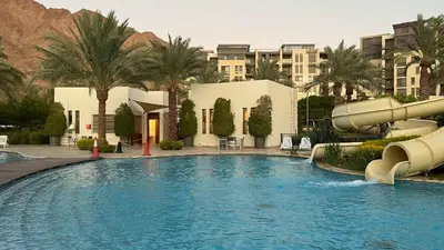 a swimming pool with a water slide in a resort at Flow - Al Raha Village in Aqaba