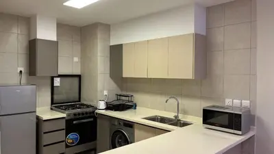 a kitchen with a sink and a stove and a refrigerator at Flow - Al Raha Village in Aqaba