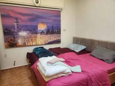 two beds in a room with a picture on the wall at شقة كبيرة مميزة للعائلات -مدخل مستقل in Amman