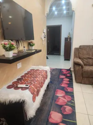 a living room with a flat screen tv and a rug at شقة كبيرة مميزة للعائلات -مدخل مستقل in Amman