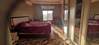 a bedroom with a bed and a mirror at شقة كبيرة مميزة للعائلات -مدخل مستقل in Amman