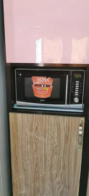 a microwave sitting on top of a wooden cabinet at شقة كبيرة مميزة للعائلات -مدخل مستقل in Amman