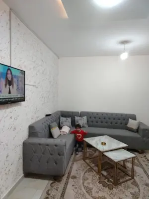 a little boy sitting on a couch in a living room at الشقة الفاخرة الحديثة in Amman