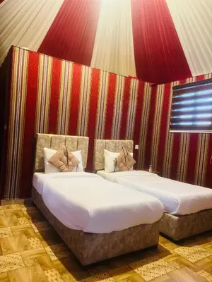 two beds sitting next to each other in a room at RUM PILLARS REST houstl in Wadi Rum
