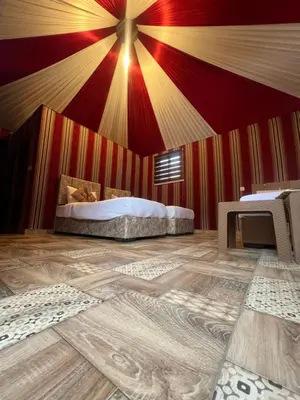 a bedroom with a bed and a red and yellow wall at RUM PILLARS REST houstl in Wadi Rum