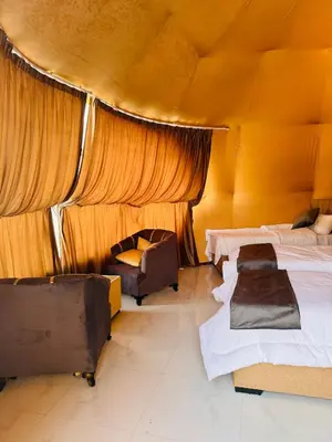 a room with two beds and a chair in it at RUM PILLARS REST houstl in Wadi Rum