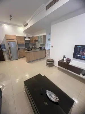a large living room with a tv and a kitchen at عبدون الشمالي in Amman