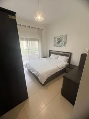 a bedroom with a bed with white sheets and a window at عبدون الشمالي in Amman