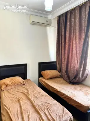 a bedroom with two beds and a curtain at studio al jubiha 1 استوديو الجبيهة in Amman