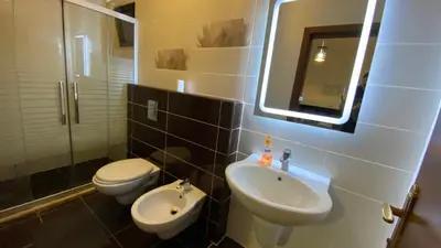 a bathroom with a sink and a toilet and a mirror at Dair Ghbar Apartment in Amman