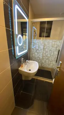 a bathroom with a sink and a mirror and a window at Dair Ghbar Apartment in Amman