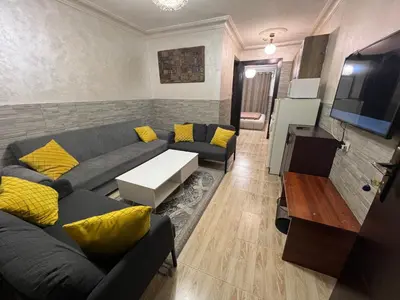 a living room with a couch and a tv at Central affordable studio in Amman