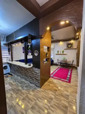 a living room with a fireplace and a dining room at Deluxe Furnished Studio Jubaiha in Amman