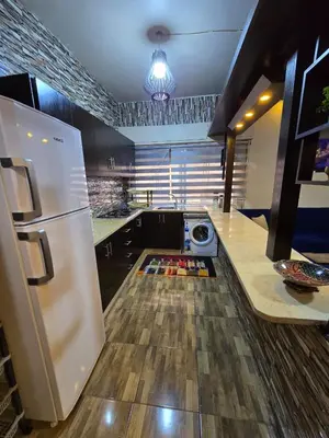 a kitchen with a white refrigerator and a counter at Deluxe Furnished Studio Jubaiha in Amman