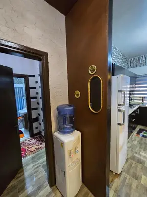 a door to a room with a refrigerator next to a kitchen at Deluxe Furnished Studio Jubaiha in Amman