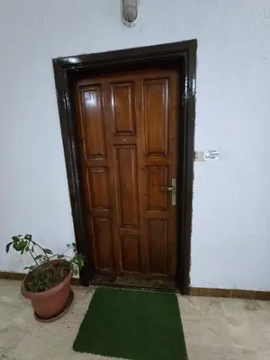 a wooden door with a green mat in front of it at Deluxe Furnished Studio Jubaiha in Amman