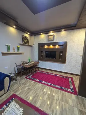 a living room with a television and a table and chairs at Deluxe Furnished Studio Jubaiha in Amman