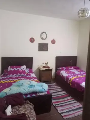 a bedroom with two beds and a clock on the wall at اهلا وسهلا في الاردن in Petra
