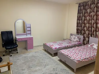 a room with two beds and a mirror and a chair at Affordable Furnished 2BR for Rent in Amman