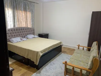 a bedroom with a bed and a chair and a window at Affordable Furnished 2BR for Rent in Amman