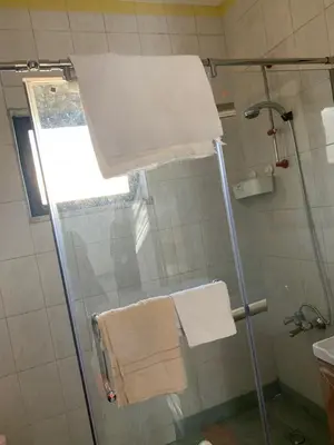 a bathroom with a shower with towels and a glass door at Affordable Furnished 2BR for Rent in Amman
