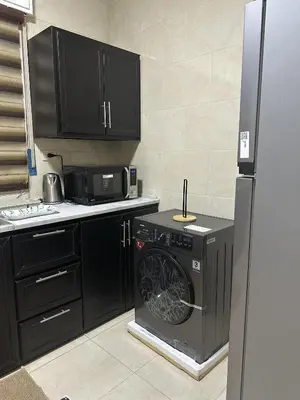a kitchen with a washing machine and a refrigerator at EVANNA SUITE & HOTELs VIP ايفانا للشقق الفندقيه VIP in Amman
