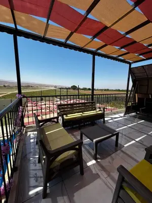 a patio with benches and tables on a balcony at شاليه هاف مليون الرامة in Al Mazār