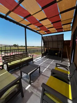 a roof deck with benches and a view at شاليه هاف مليون الرامة in Al Mazār