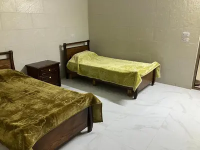 a room with two beds and a dresser in it at Kenda house in Ajloun