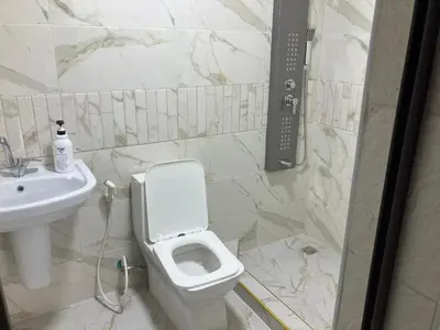 a bathroom with a white toilet and a sink at Kenda house in Ajloun