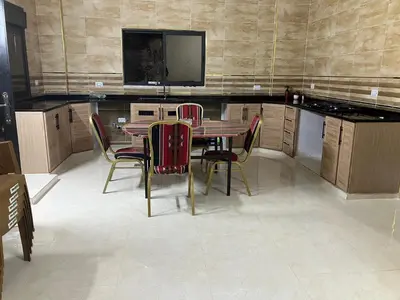 a kitchen with a table and chairs and a tv at Kenda house in Ajloun