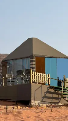 a building with a deck with tables and chairs at LUXURY camp in Disah