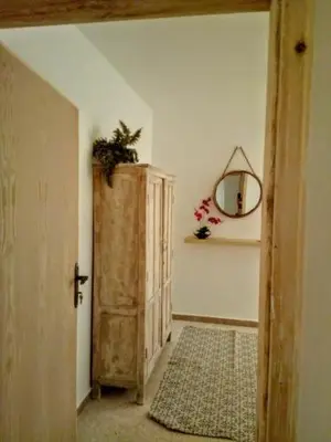 a hallway with a door and a mirror on a wall at B&B petrafarmhouse in Wadi Musa