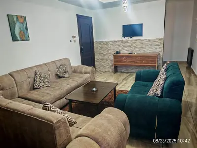 a living room with two couches and a tv at EVANNA SUITE AND HOTELs ايفانا للشقق الفندقيه و المفروشه in Amman