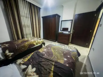 a hotel room with two beds and a television at EVANNA SUITE AND HOTELs ايفانا للشقق الفندقيه و المفروشه in Amman