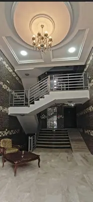 a room with a chandelier and stairs with a table at EVANNA SUITE AND HOTELs ايفانا للشقق الفندقيه و المفروشه in Amman
